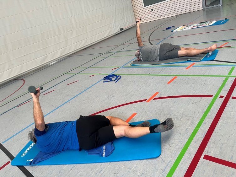 Teilnehmer beim seitlichen Training mit Fitnessstab